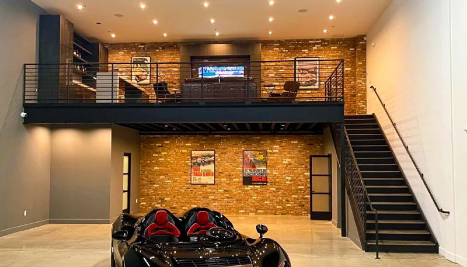 Finished unit with a brick-walled mezzanine lounge above a black roadster